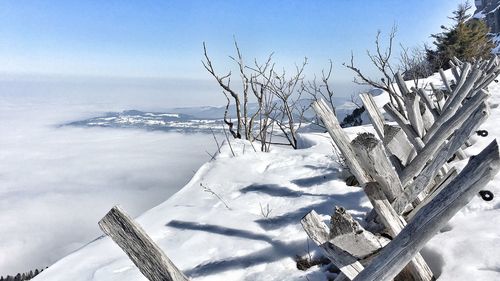 Wooden fence on snow covered cliff during foggy weather