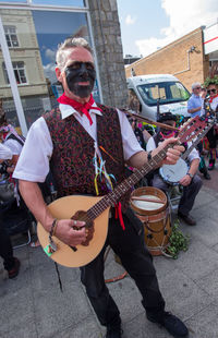 Full length of man playing guitar on street