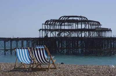 Chairs against brighton pier at beach