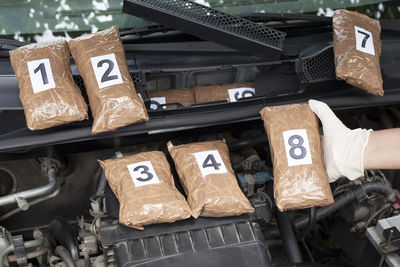 Cropped hand of person holding packet in car