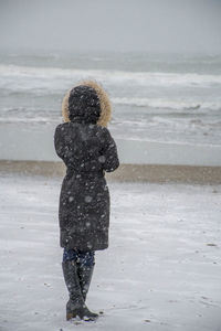 Rear view of woman standing on beach