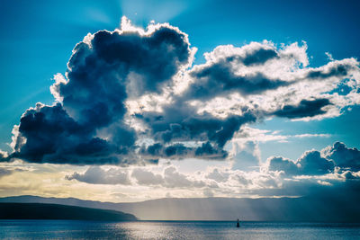 Sun behind an impressive cloud over the adriatic sea with islands and a buoy