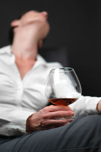 Midsection of woman holding wineglass