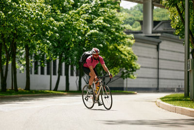 Side view of man riding bicycle on street