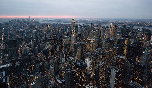 High angle view of city lit up at sunset