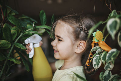 Close-up of girl looking at flowering plants