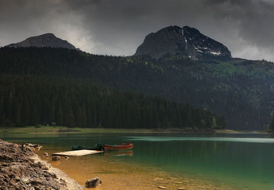 Scenic view of lake by mountains against sky