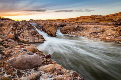 Scenic view of flowing river through rock formation in desert