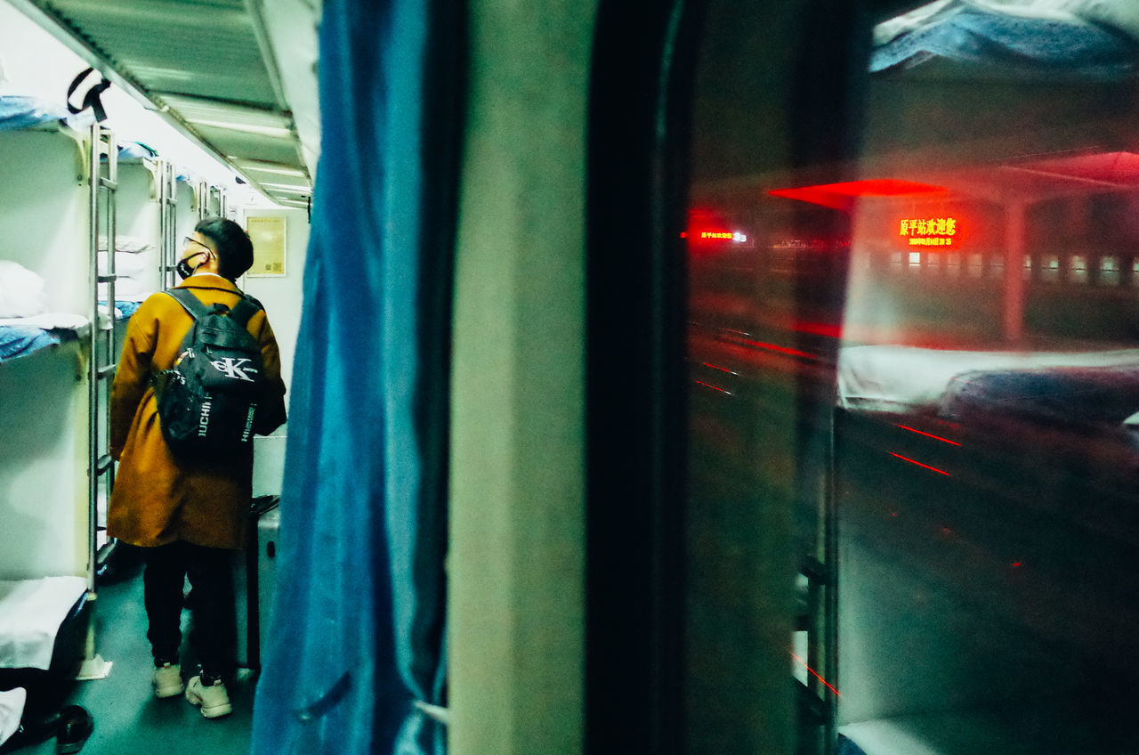 REAR VIEW OF MAN STANDING AT TRAIN