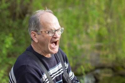 Portrait of young man looking away while standing outdoors