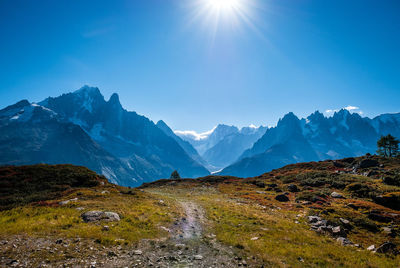 Scenic view of snowcapped mountains against blue sky