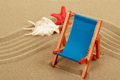 High angle view of empty chair on sand