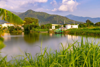 Scenic view of lake by buildings against sky