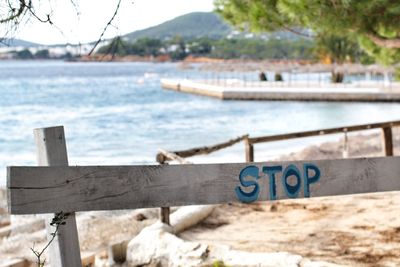 Close-up of text on railing against sea