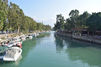 Boats moored in river against sky