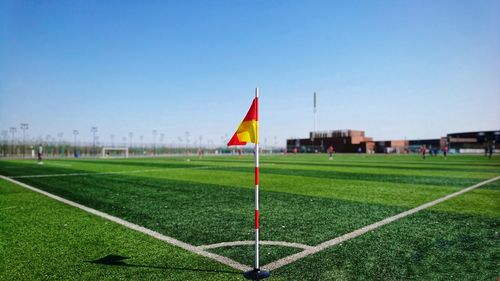 Flag on soccer field against clear sky