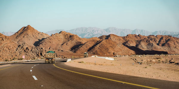 Road by mountain against sky