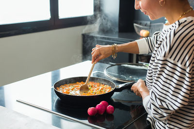 Midsection of man preparing food in kitchen