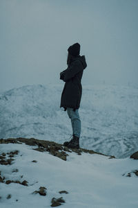 Rear view of man standing on snow covered land