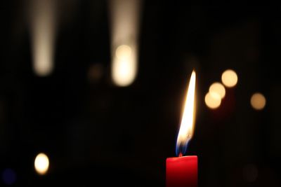 Close-up of lit candle at night