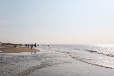 People at beach against sky