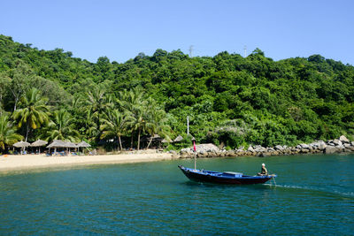 Boats sailing in sea against clear blue sky