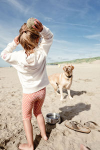 Full length of girl playing with dog 