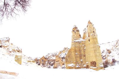 Built structure on snow covered land against clear sky