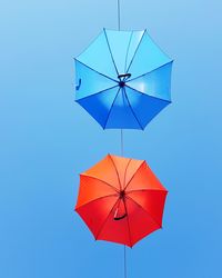 Close-up of red umbrella against clear blue sky