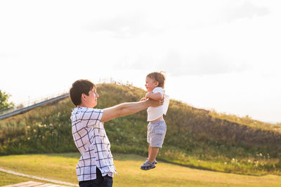 Full length of father and son standing outdoors