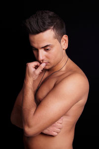 Close-up of shirtless baby against black background