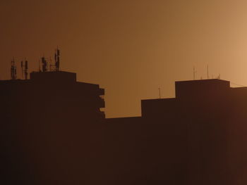 Silhouette buildings against sky during sunset