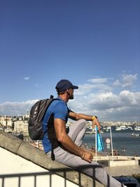 Man sitting on boat against sky