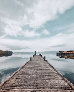 Wooden pier over sea against sky