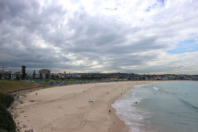 Scenic view of beach by buildings against sky