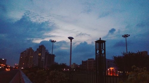 High angle view of illuminated city against cloudy sky