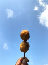 Person holding ice cream against sky