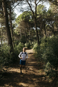 Woman walking on footpath in forest