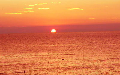 Scenic view of sea against orange sky