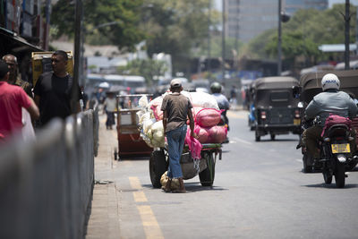 Rear view of people walking on city street