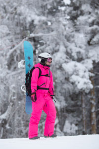 Woman with umbrella standing on snow