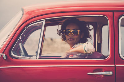 Portrait of woman wearing sunglasses sitting in car