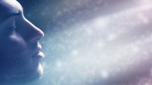 Close-up portrait of a man looking away against sky