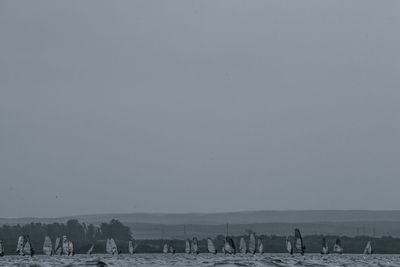 People on beach against clear sky