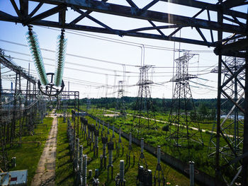 Electricity pylon on field against sky