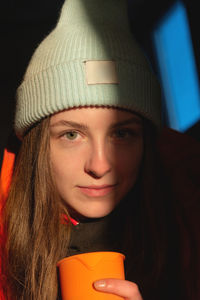 Portrait of a young satisfied smiling girl in cold weather, dressed in colorful clothes and a warm