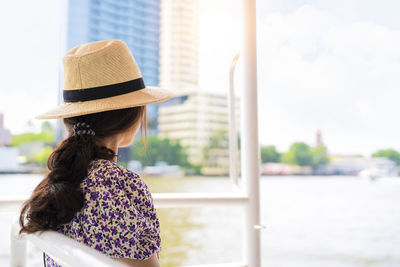 Rear view of woman in hat against sky