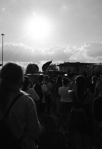 Rear view of people standing against sky