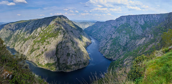 Panoramic view of river amidst mountains against sky