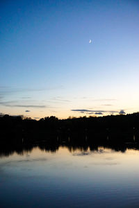 Scenic view of lake against sky at dusk